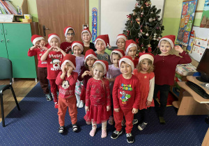 Wspólne zdjęcie wszystkich dzieci w czapkach Świętego Mikołaja.
