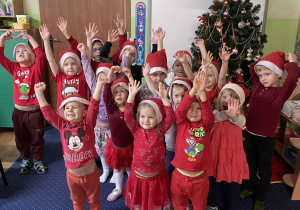 Wspólne zdjęcie wszystkich dzieci w czapkach Świętego Mikołaja.
