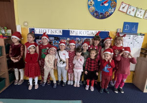 Wspólne zdjęcie wszystkich dzieci w czapkach Świętego Mikołaja.