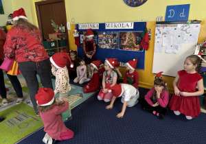 Pani rozdaje dzieciom prezenty od Świętego Mikołaja.