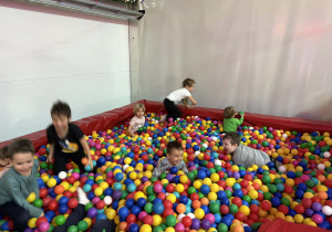 dzieci bawią się w basenie z kolorowymi piłkami