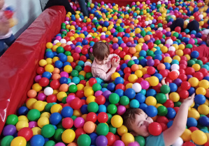 dzieci bawią się w basenie z kolorowymi piłkami