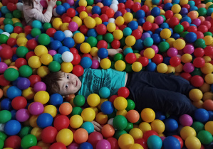 dzieci bawią się w basenie z kolorowymi piłkami