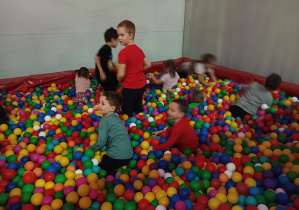 dzieci bawią się w basenie z kolorowymi piłkami