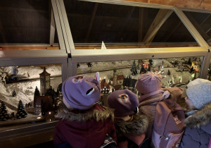 Dzieci oglądają interaktywną alpejką wioskę.