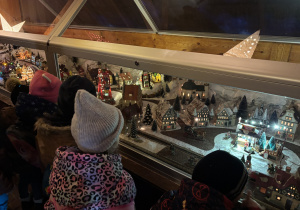 Dzieci oglądają interaktywną alpejką wioskę.