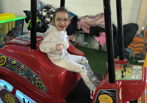 Dziewczynka siedzi w samochodzie.