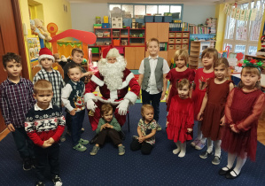 dzieci z grupy 2 pozują do zdjęcia z Świętym Mikołajem