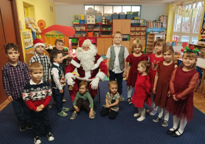 dzieci z grupy 2 pozują do zdjęcia z Świętym Mikołajem