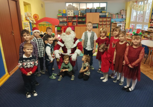 dzieci z grupy 2 pozują do zdjęcia z Świętym Mikołajem