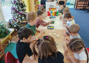 dzieci malują i ozdabiają ozdoby choinkowe