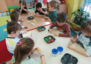 dzieci malują i ozdabiają ozdoby choinkowe