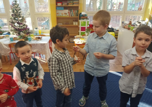 dzieci składają sobie życzenia, dzielą się opłatkiem