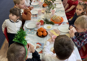 Dzieci siedzą przy świątecznym stole.