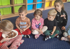 Dzieci siedzą w kole i wąchają herbatę.