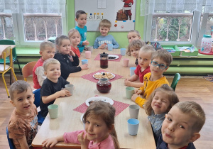 Dzieci siedzą przy stole.