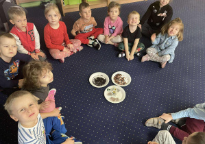 Dzieci siedzą w kole i oglądają różne rodzaje herbaty.