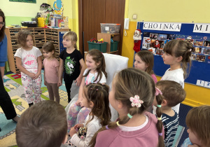 Dzieci ustawione w kole śpiewają "100 lat!".