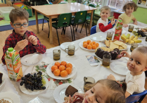 Dzieci siedzą przy wigilijnym stole.