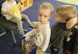 Dzieci ustawione w rzędzie stoją przed chłopcem.