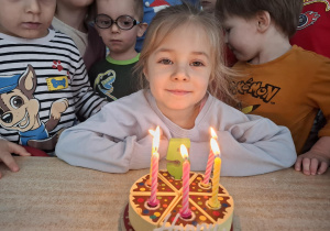 dziewczynka świętuje urodziny, dzieci składają jej życzenia