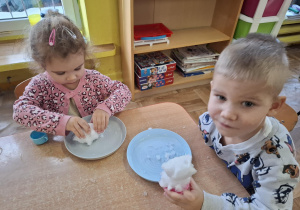 eksperymenty ze śniegiem, dzieci mają na talerzykach śnieg i różne akcesoria