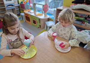 eksperymenty ze śniegiem, dzieci mają na talerzykach śnieg i różne akcesoria