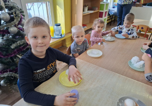 eksperymenty ze śniegiem, dzieci mają na talerzykach śnieg i różne akcesoria