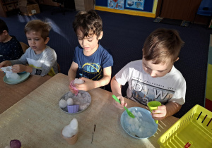 eksperymenty ze śniegiem, dzieci mają na talerzykach śnieg i różne akcesoria