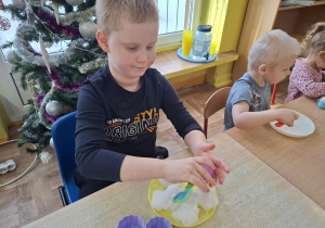 eksperymenty ze śniegiem, dzieci mają na talerzykach śnieg i różne akcesoria