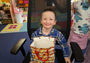 chłopiec świętuje urodziny, trzyma torebkę z cukierkami