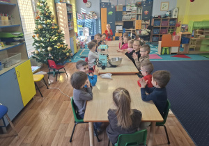 dzień popcornu w grupie 1, dzieci przy stolikach jedzą popcorn