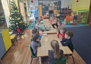 dzień popcornu w grupie 1, dzieci przy stolikach jedzą popcorn