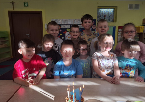 chłopiec świętuje urodziny, dzieci składają mu życzenia