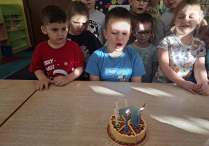 chłopiec świętuje urodziny, dzieci składają mu życzenia