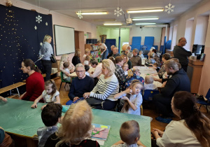 warsztaty plastyczne na sali gimnastycznej. dzieci razem z babciami i dziadkami wykonują ramki z lusterkami