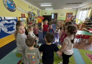 Dzieci ustawione w kole śpiewają "100 lat".