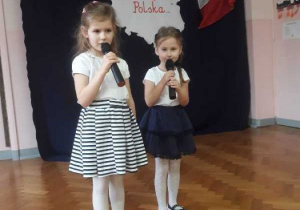 Dwie dziewczynki recytują wiersz.