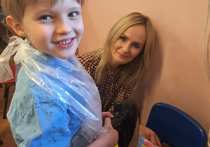 Chłopiec trzyma suszarkę.