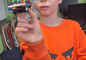 Chłopiec pokazuje co zbudował z klocków Lego.