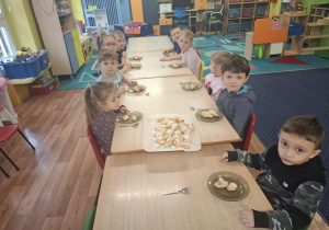 dzieci przy stolikach próbują rogaliki