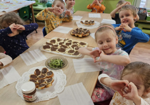 Dzieci siedzą przy stole.
