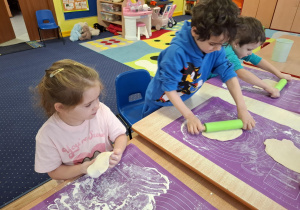 dzieci samodzielnie przy stolikach przygotowują pizzę