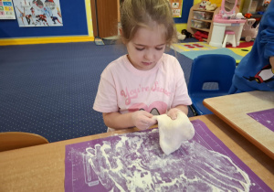 dzieci samodzielnie przy stolikach przygotowują pizzę