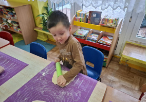 dzieci samodzielnie przy stolikach przygotowują pizzę