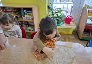 chłopiec zjada pizzę