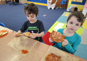 dzieci jedzą pizzę