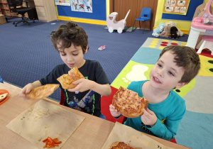 dzieci jedzą pizzę