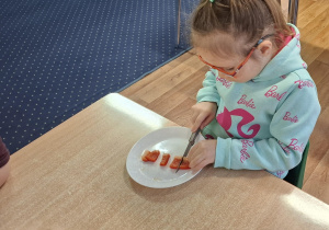 dzieci przy stolikach przygotowują pizzę