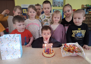 chłopiec świętuje urodziny, dzieci składają mu życzenia